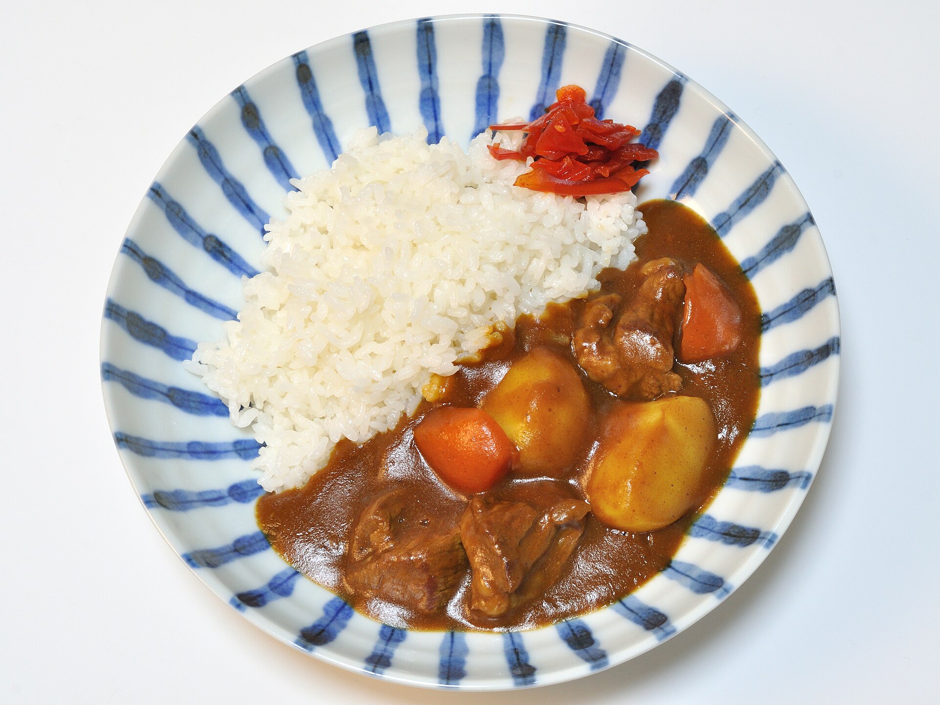 밥 옆에 걸쭉한 쇠고기 카레를 담은 접시