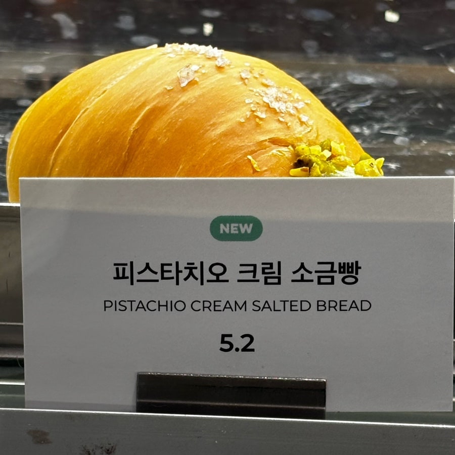피스타치오 크림 소금빵과 한글·영어 제품명이 적힌 노티드 부산해운대점 진열표