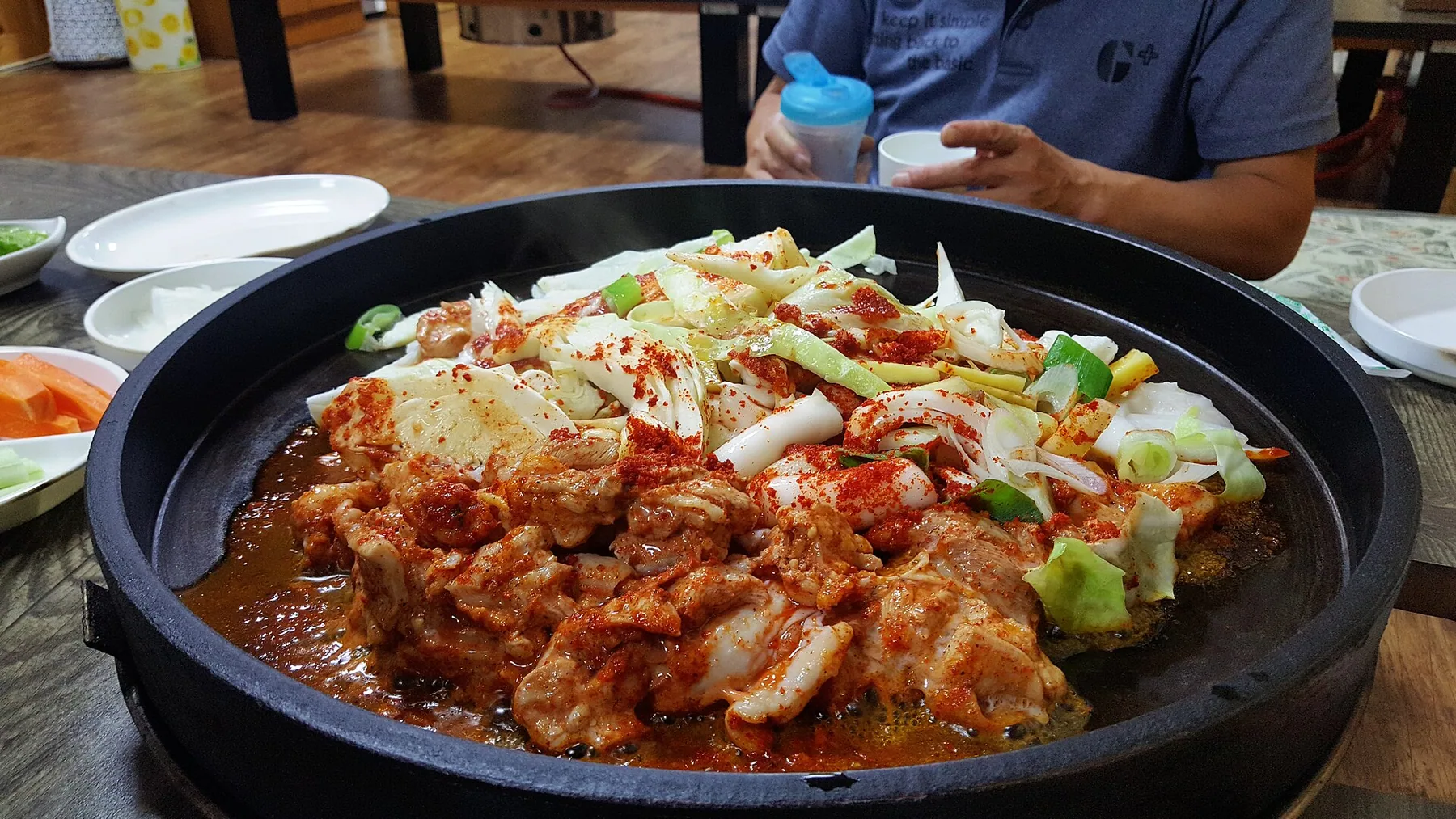 넓은 철판에서 닭고기와 양배추, 떡을 함께 볶는 춘천식 닭갈비