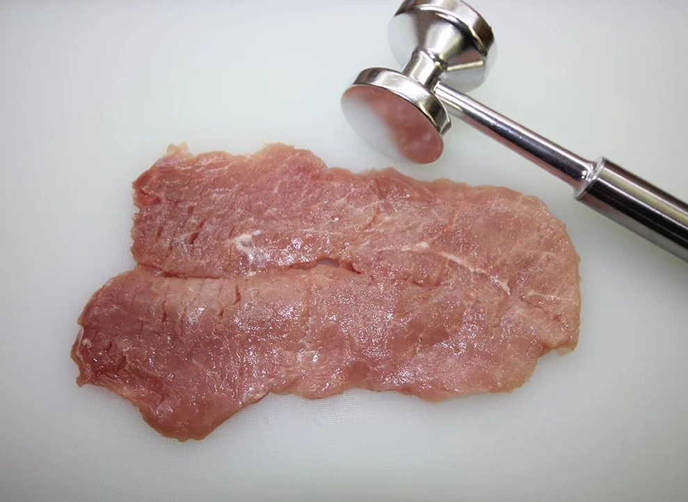 고기망치로 두드리기 전의 두툼한 송아지고기 조각