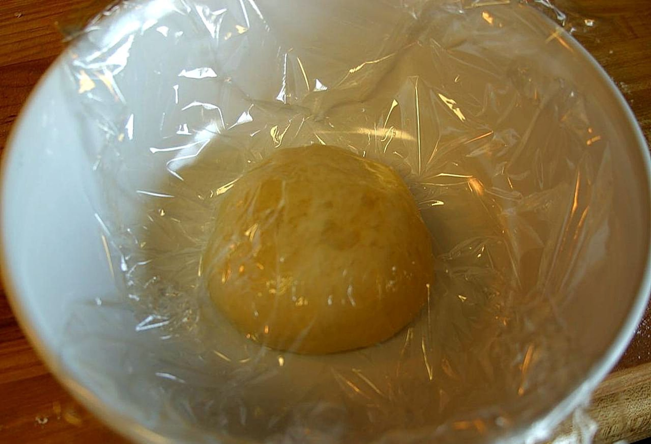 주방 작업대에서 피자 반죽을 펴는 과정