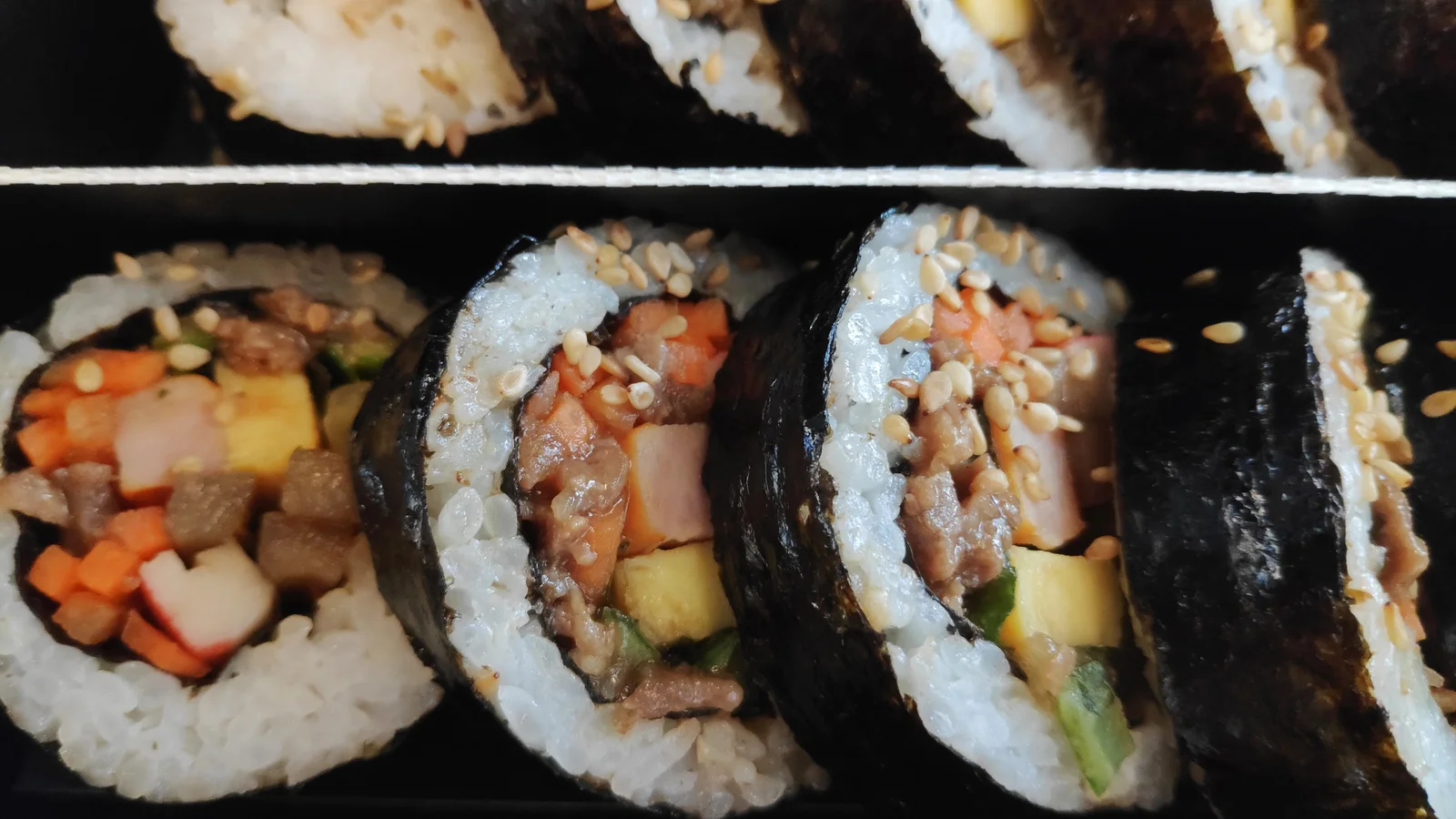 열차 안 도시락 용기에 담긴 김밥 여러 조각