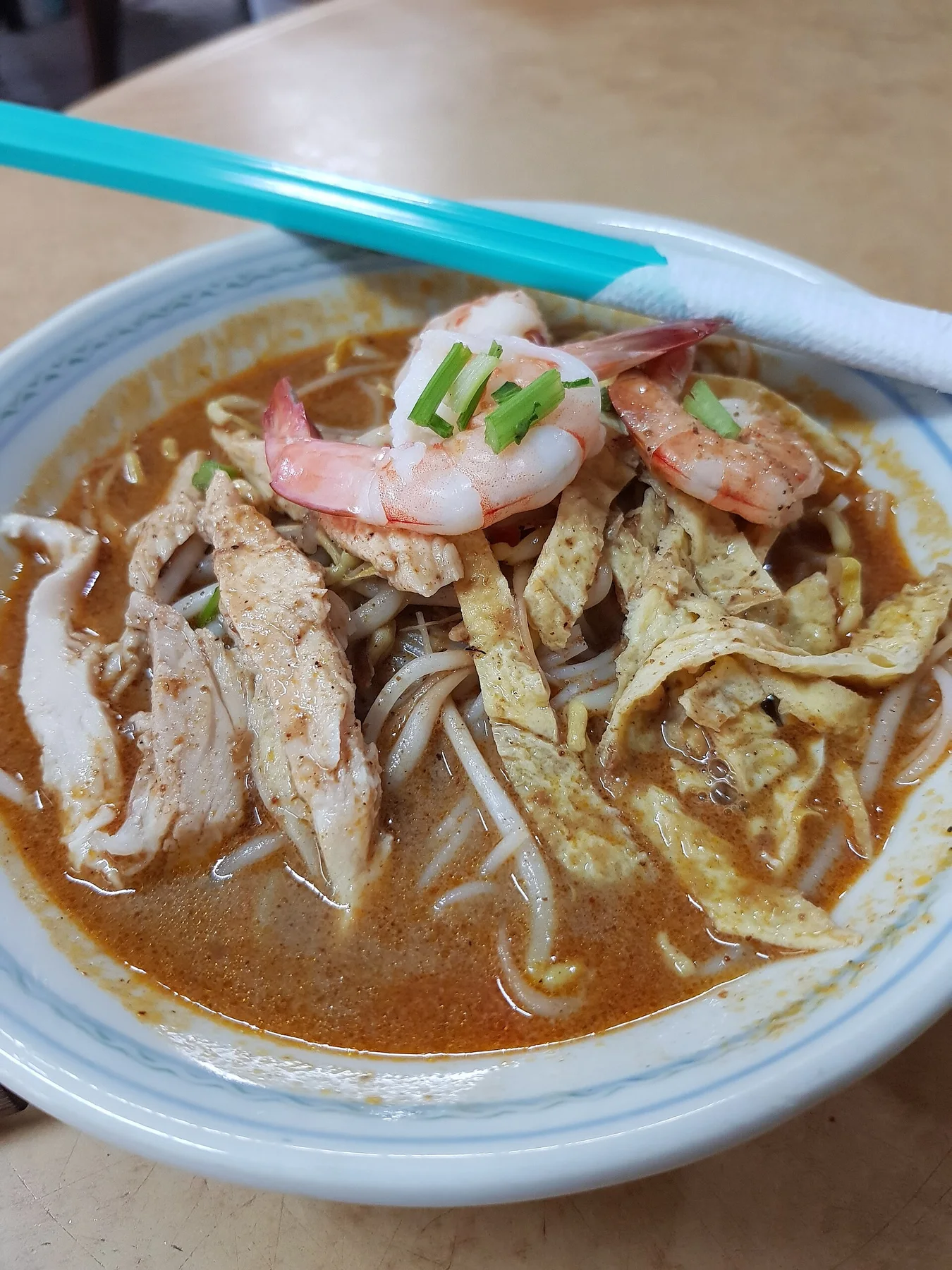 새우와 닭고기와 달걀지단을 올린 사라왁락사