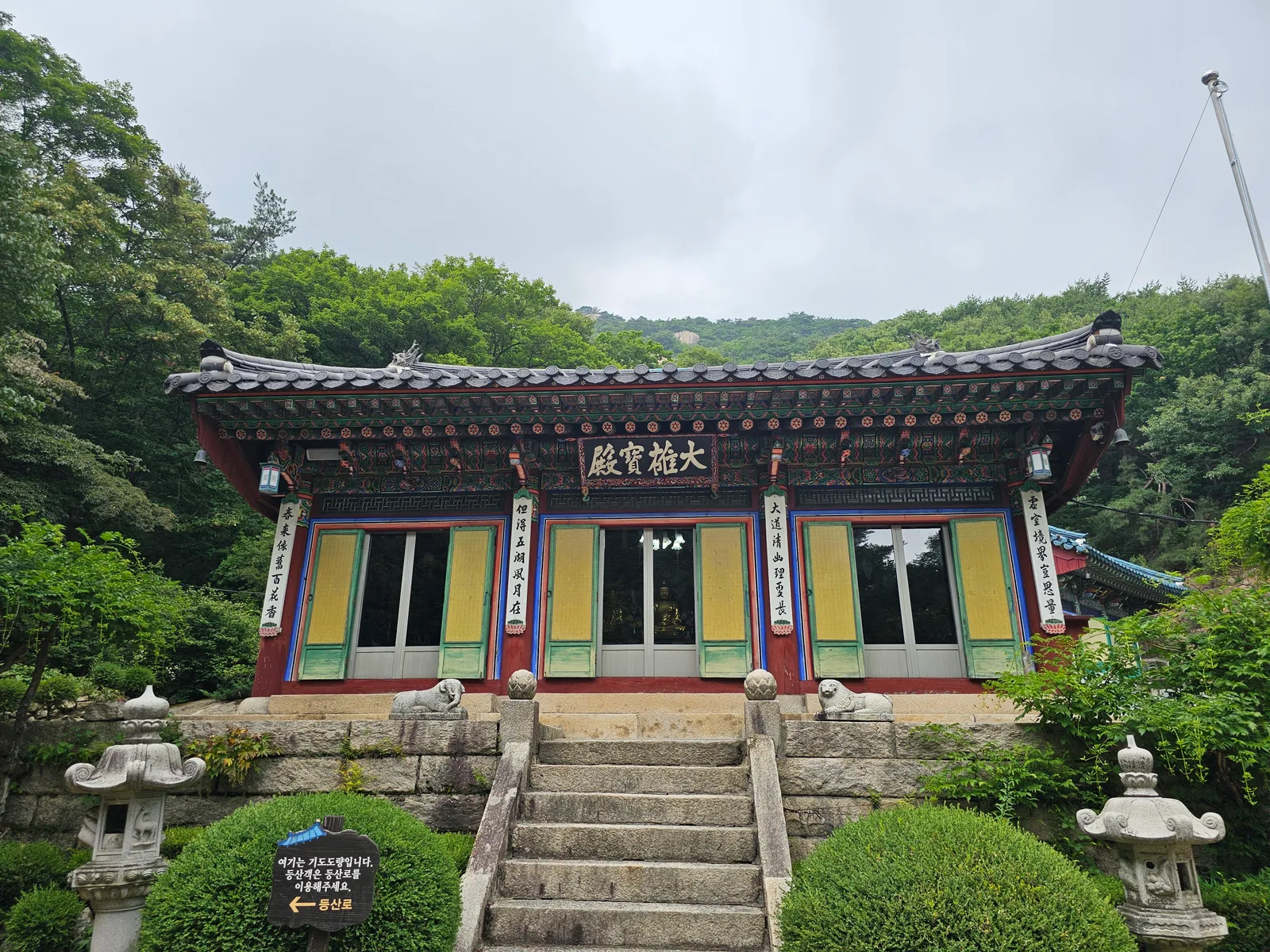 숲을 등지고 돌계단 위에 선 수락산 내원암 전각