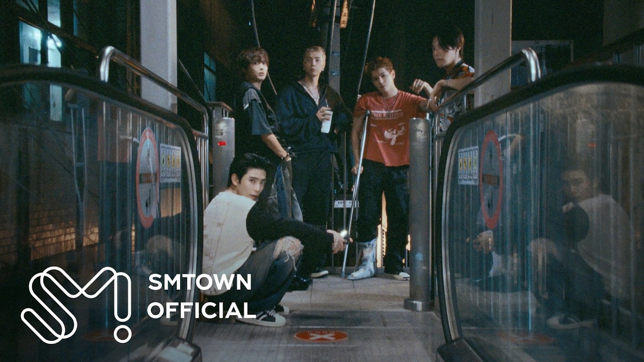 서울 도심의 밤거리에서 나란히 걸어가는 NCT 127 멤버들