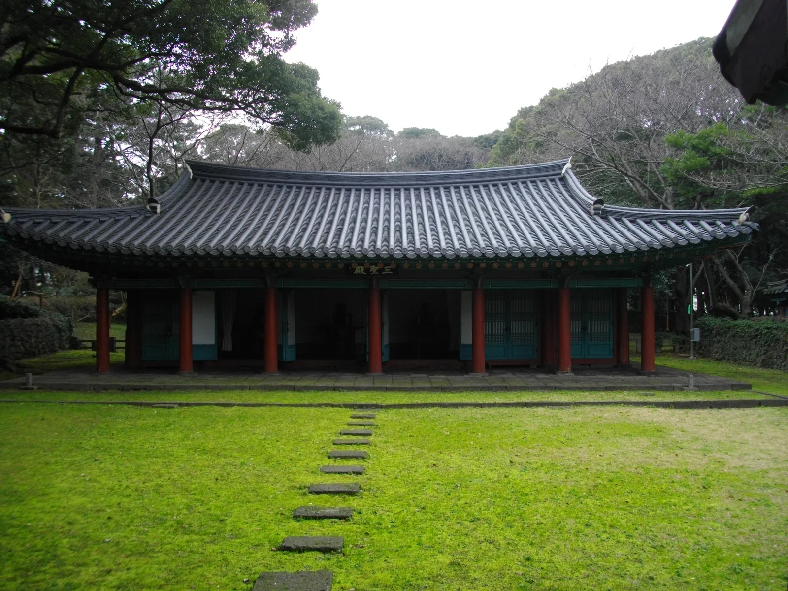 제주 삼성혈 경내의 전각과 잔디, 주변의 큰 나무